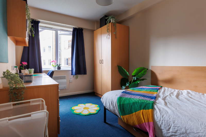 Bedroom with bed, wardrobe, desk and window