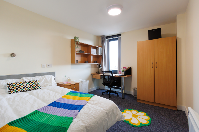 Bedroom with bed, shelving, desk and window