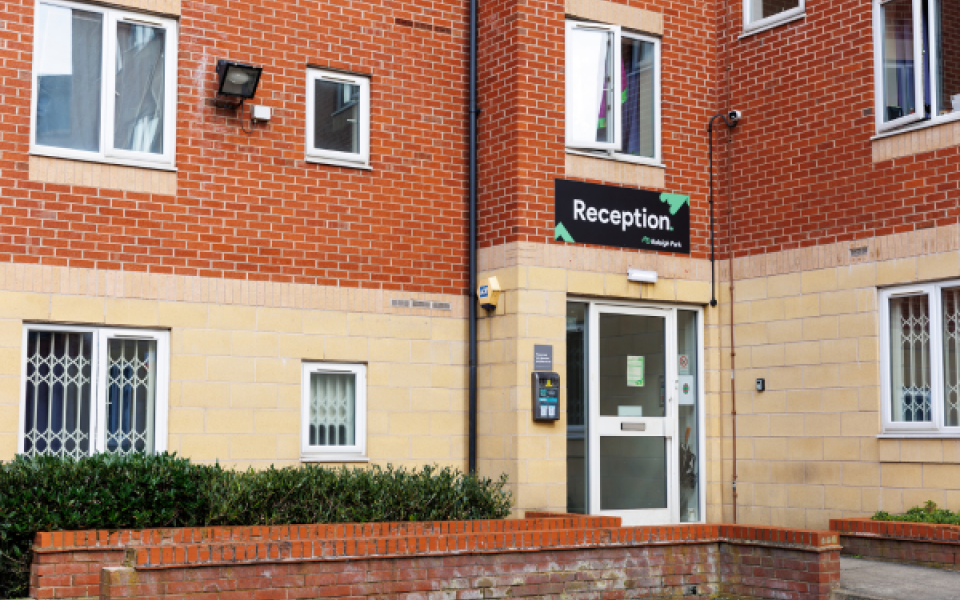 Image of an entranceway to a block of flats with a reception sign