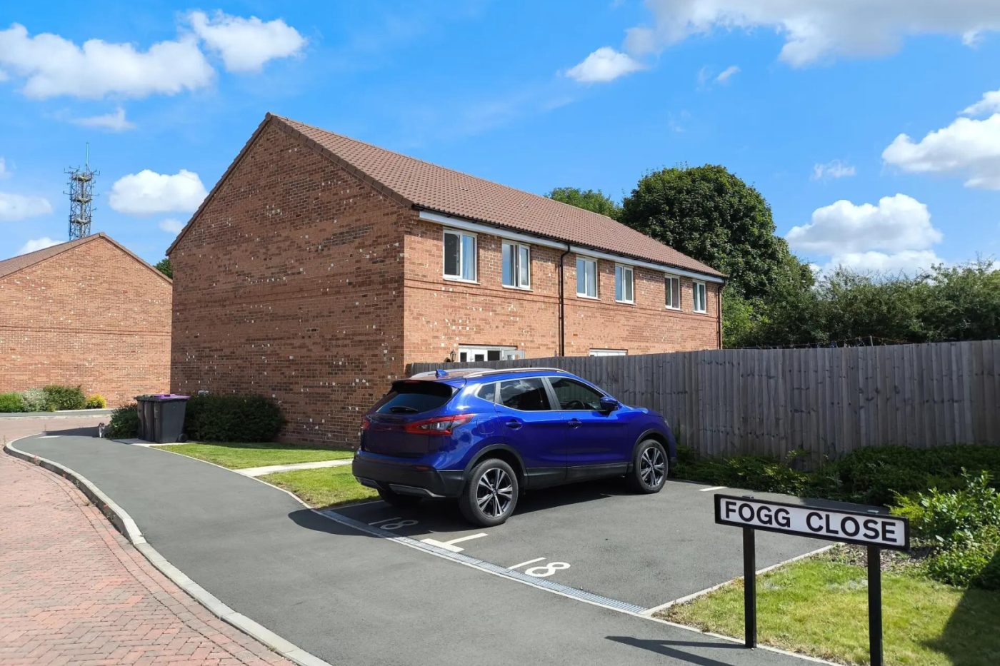 Car parking space on Fogg Close with a terrace of houses in the background