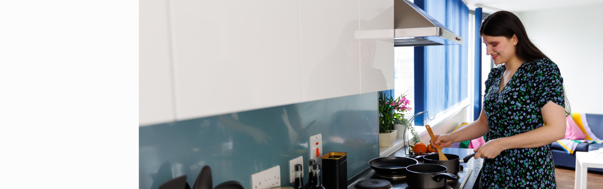 A woman stirring a pan on the hob