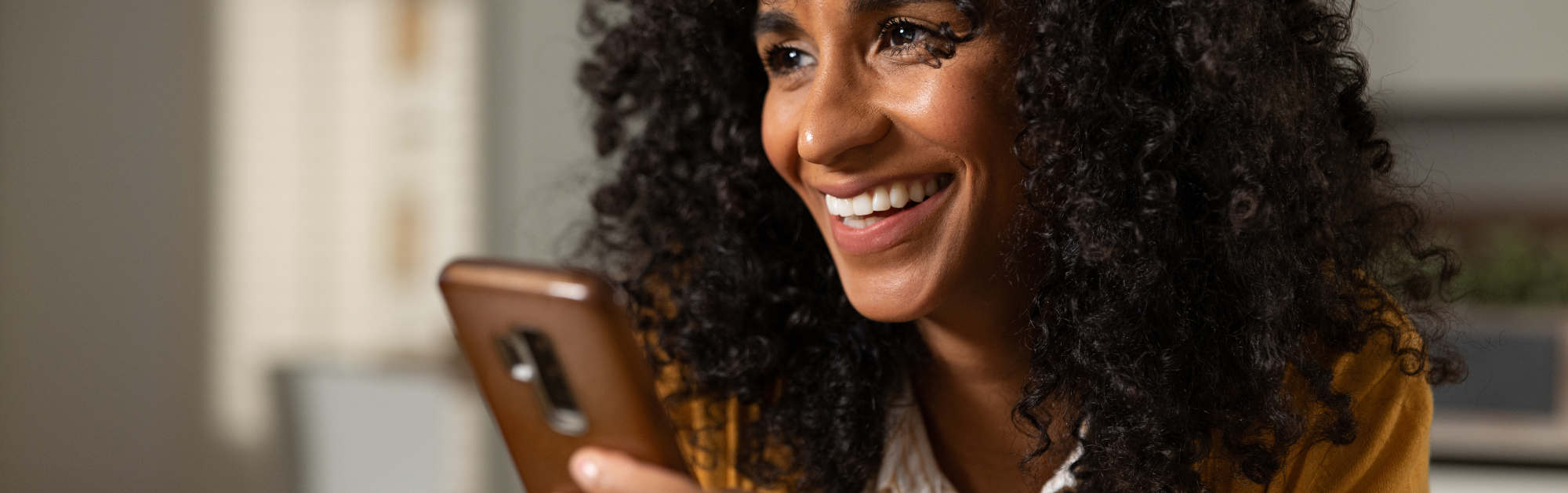 A woman smiling with a phone in their hand