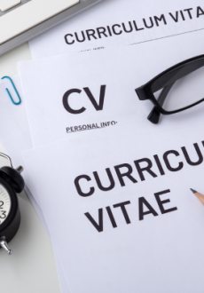 A picture of a blank CV with a pencil, computer mouse, a pair of glasses and a clock