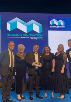 A group of people stood on a stage smiling with an award