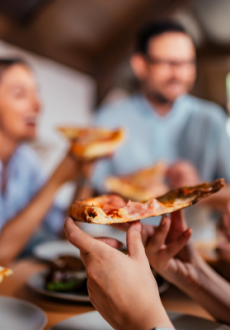 People eating slices of  pizza