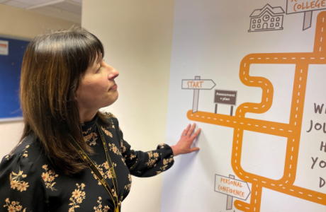 A woman looking at a road map on a wall.