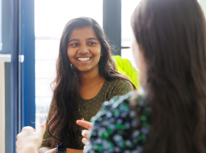 Student talking to another student and smiling