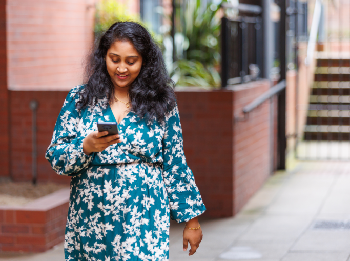 Student on their phone walking down the street