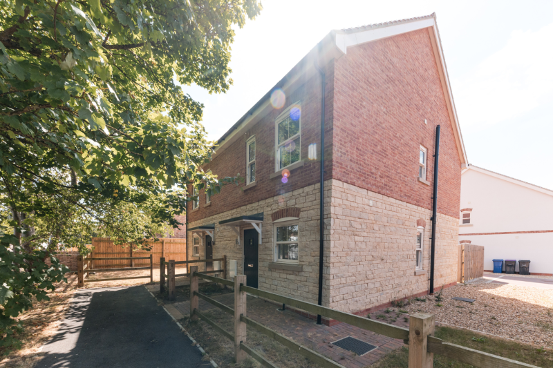 Front of a semi detached house in the sunshine with a tree in leaf