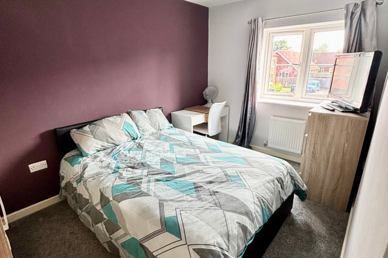 Bedroom with a double bed, storage and a TV by the window