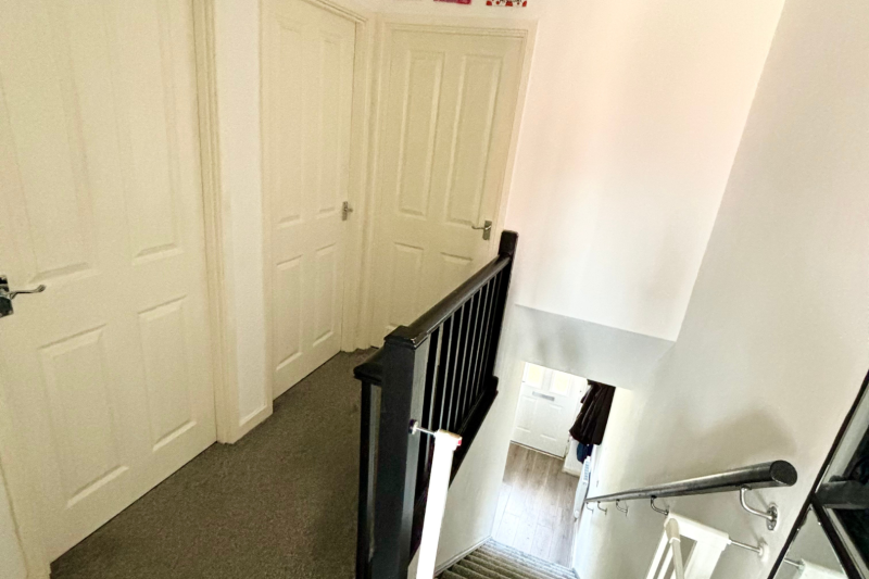 Upstairs landing looking down the stairs to the front door