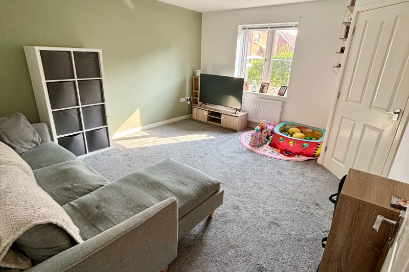 Living room  with sofa, storage, TV and kids play pit