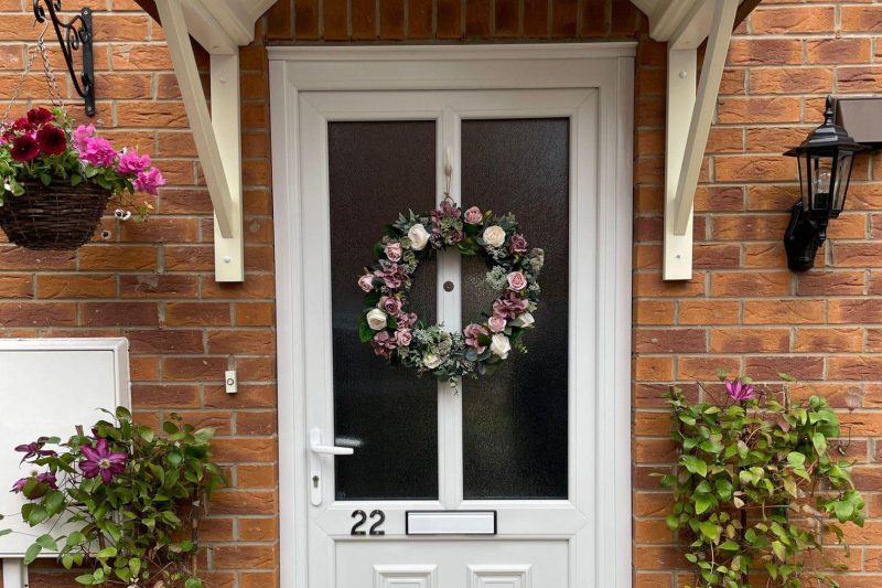 Front door with wreath and flowers