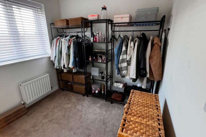 Clothes rail filled with clothes in a small to medium sized room