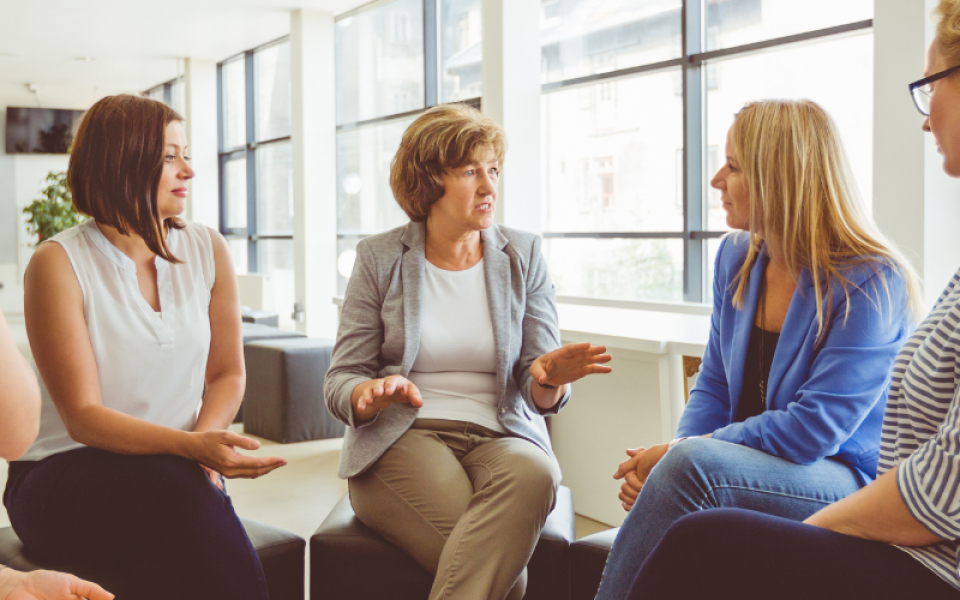 A group of people sat in a circle chatting