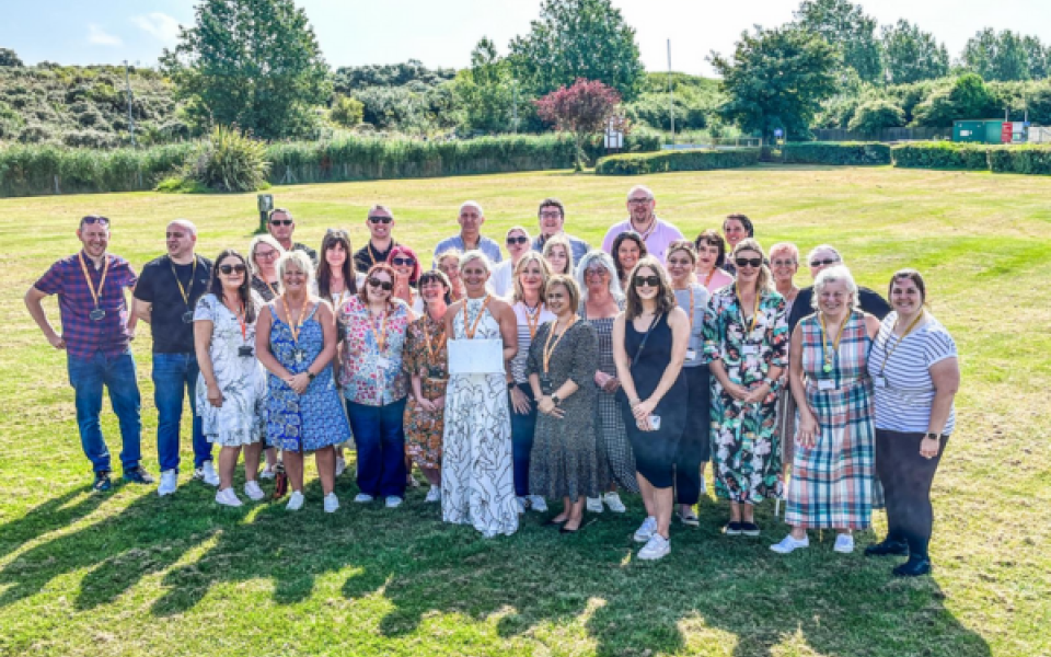 A group of people smiling in the sunshine