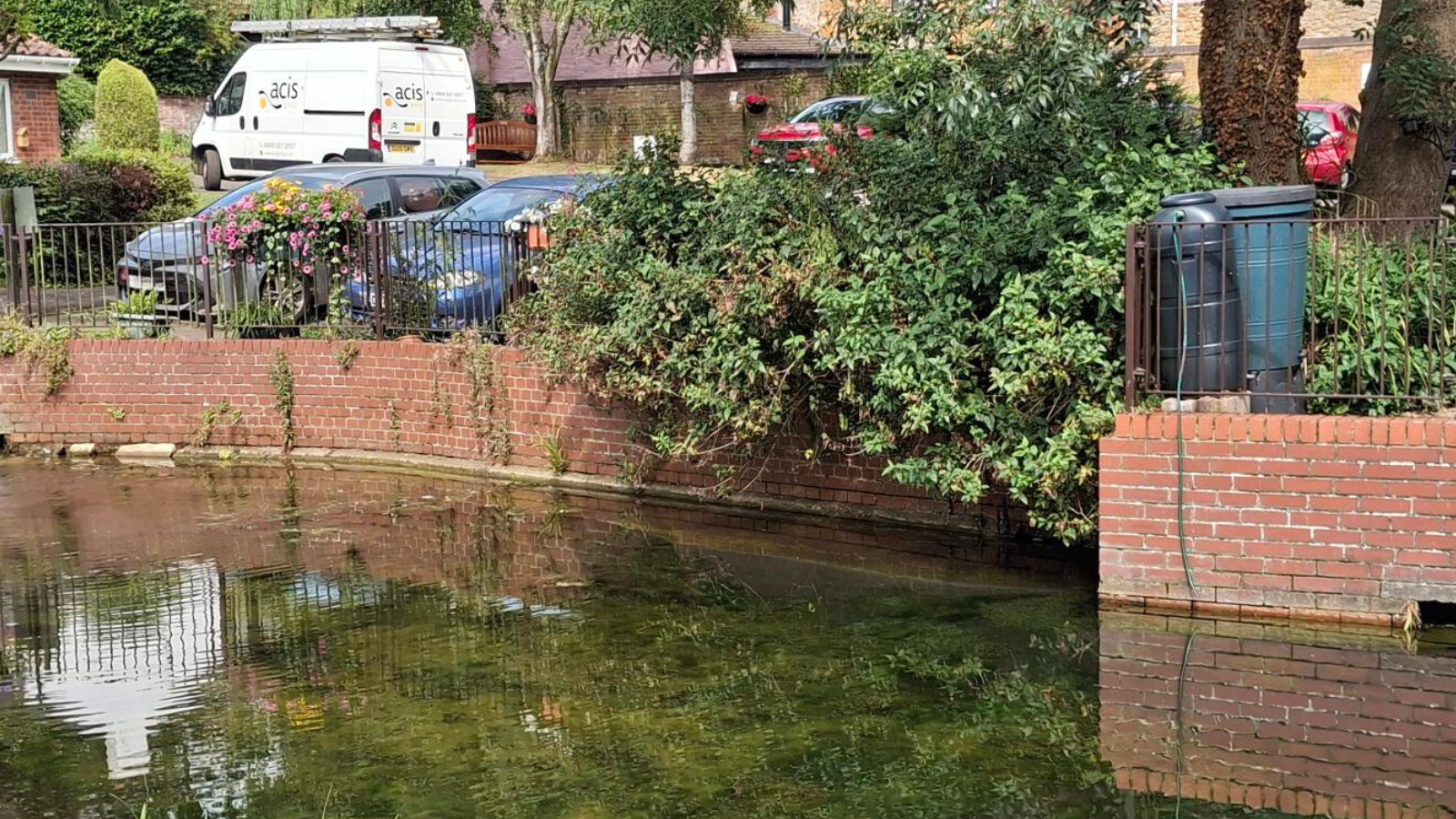 A picture of the pond at Westbrooke Grove with an Acis Group Van in the background